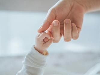 baby hand holding parent's hand